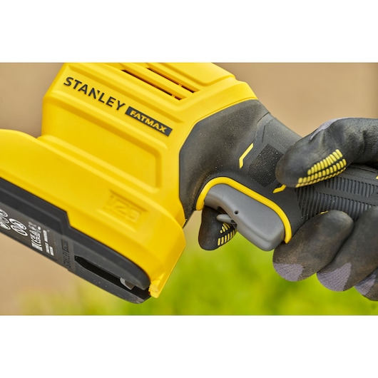 STANLEY STCSS20B cordless FATMAX tool close-up held by gloved hand, showing trigger and yellow casing.