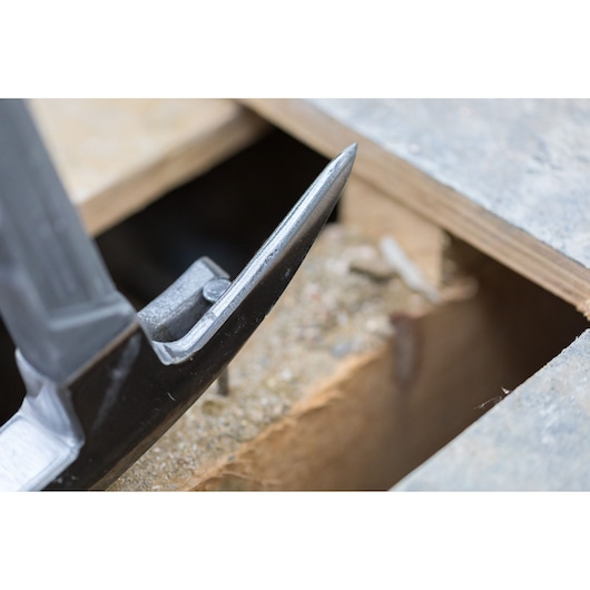 Close-up of STANLEY STHT0-51311 claw hammer head beside wooden boards, photography.