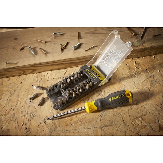 Stanley STHT0-70885 screwdriver and bit set on wood, yellow and black handle, open case.