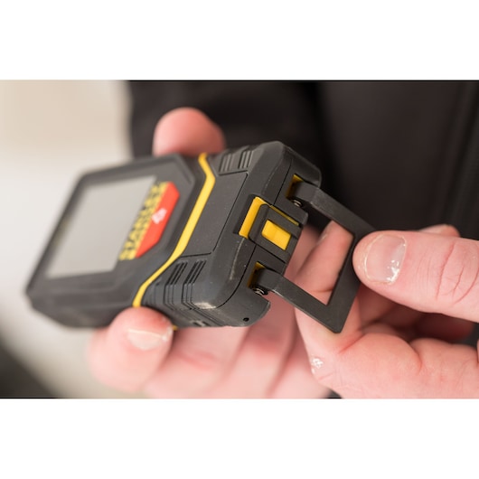 STANLEY STHT1-77139 laser distance measurer with pull-out clip, close-up in hand.