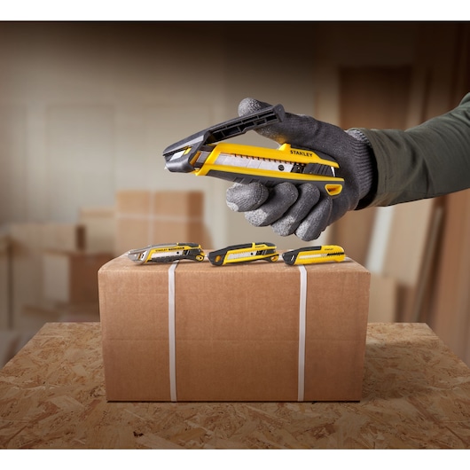 STANLEY STHT10501-0 utility knives on a package box, close-up photography in a warehouse setting.