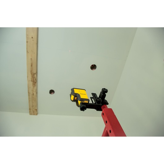 STANLEY STHT77503-1 laser level attached to red ladder during ceiling installation.