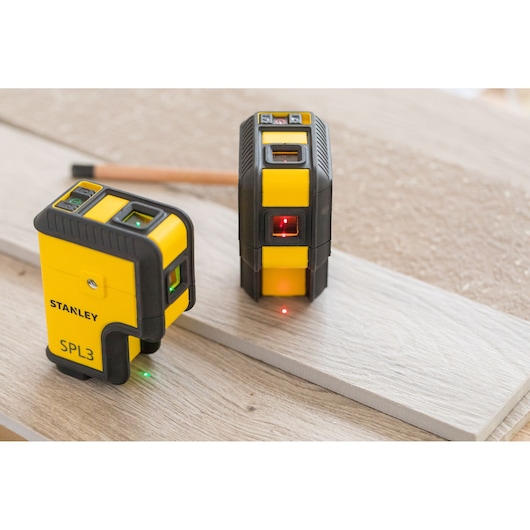 STANLEY STHT77503-1 laser levels in yellow and black, placed on wooden board, side and front angles.