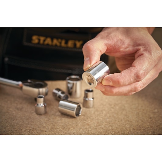 STANLEY STMT86309-0 socket set photography, close-up of chrome sockets and ratchet on work surface.