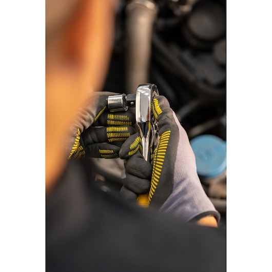 STANLEY STMT86532-0 ratchet tool held in gloved hands during automotive work, close-up photography.
