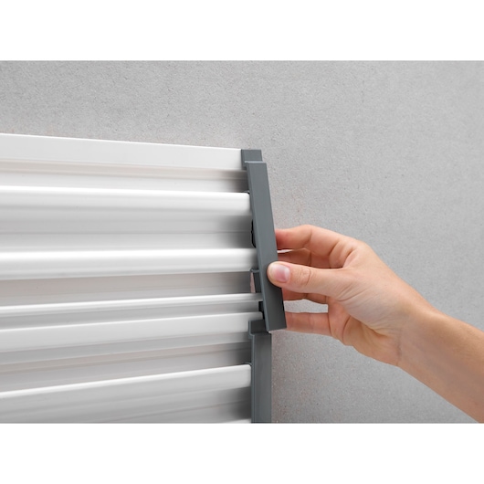STANLEY STST82611-1 hand adjusting grey wall-mounted metal rail, close-up angle.