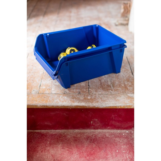 STANLEY STST82746-1 blue storage bin holding yellow tape measures, angled on wooden floor.