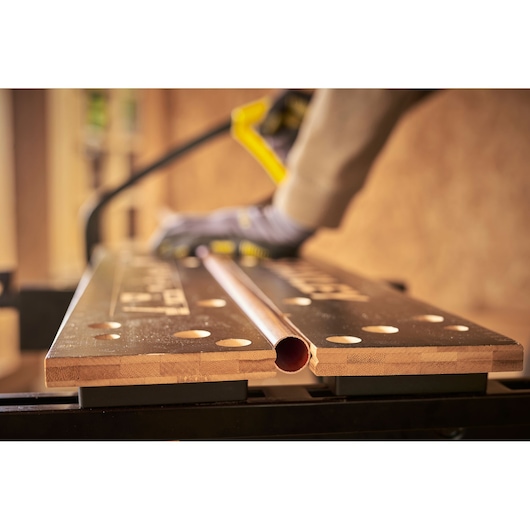 STANLEY STST83400-1 workbench photography, angled view with copper pipe and gloved hand.