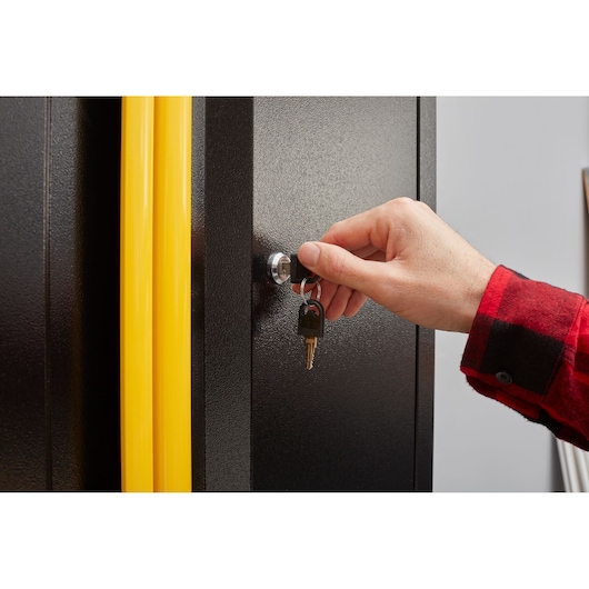 Photo of STANLEY STST97598-1 cabinet with yellow handles being locked with a key, close-up view.