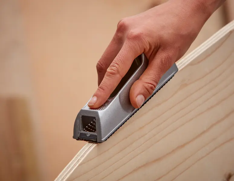 Foto von STANLEY 5-21-399 Handhobel beim Glätten einer Holzkante, Nahaufnahme.